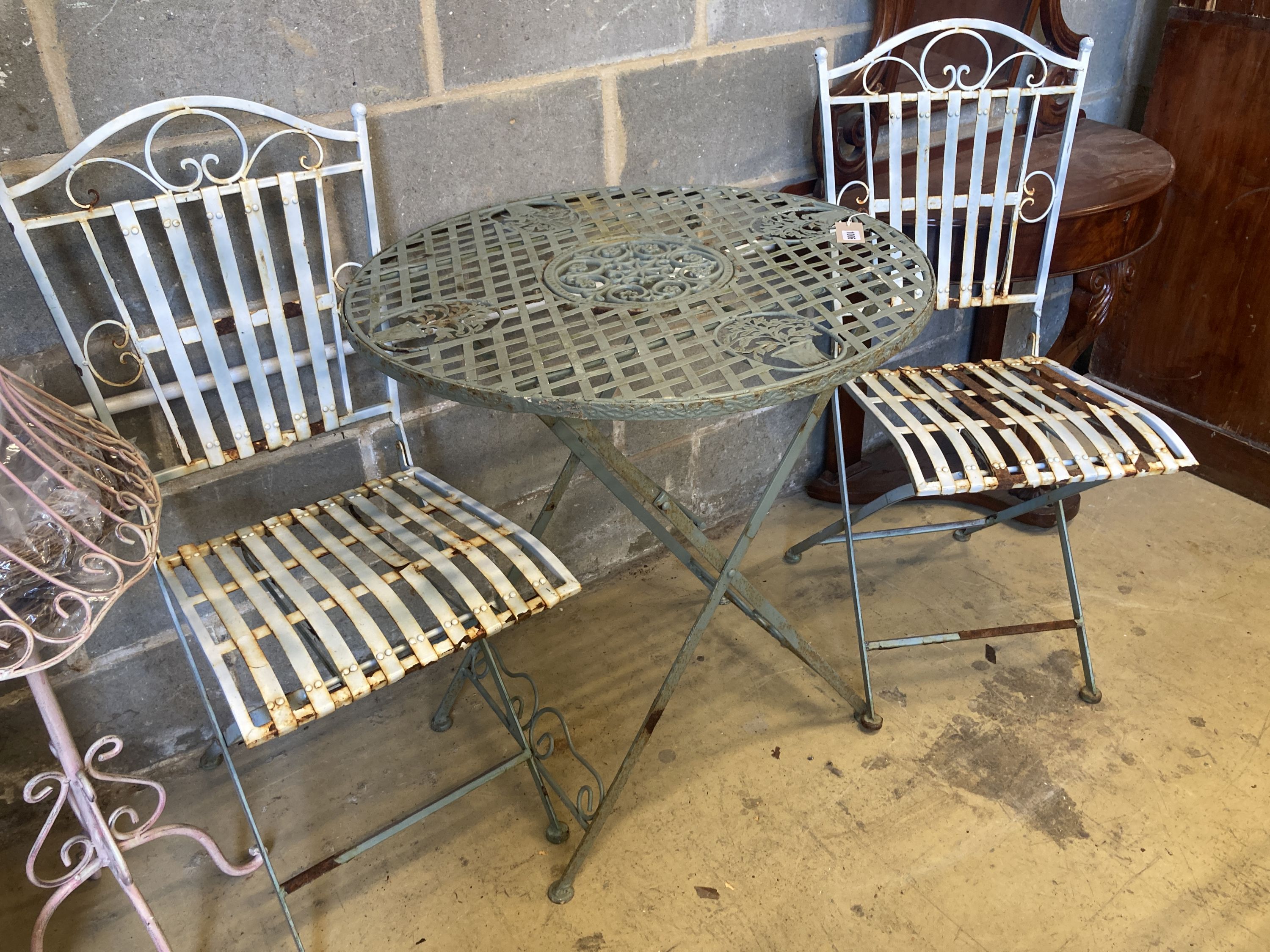 A painted circular aluminium folding garden table, 71cm diameter, height 76cm, together with a pair of folding garden chairs